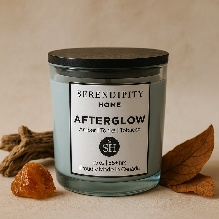 Serendipity Home 'Afterglow' candle beside amber, tonka and tobacco leaves