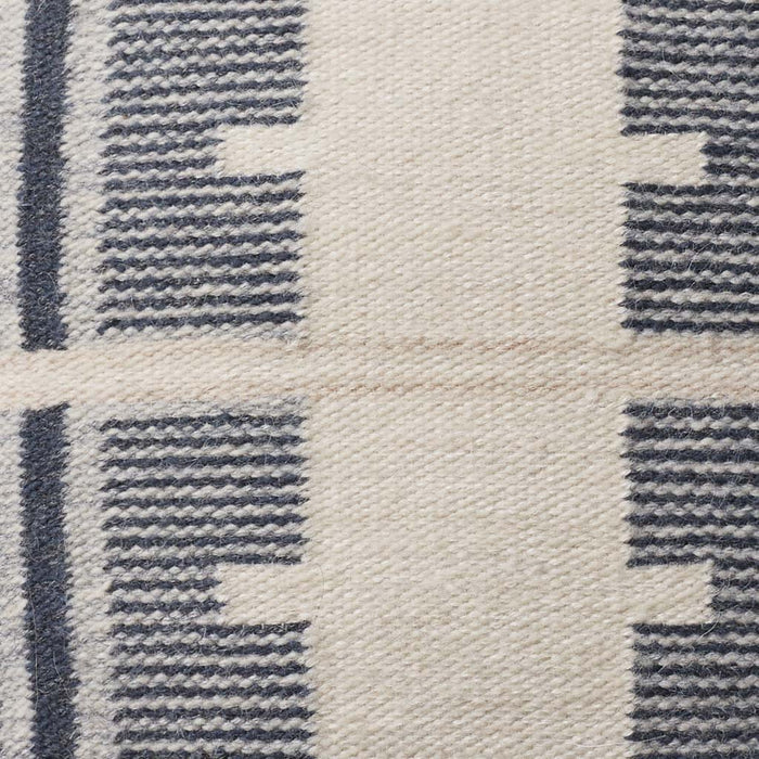 Detail of navy and ecru stitching, stone-blue
