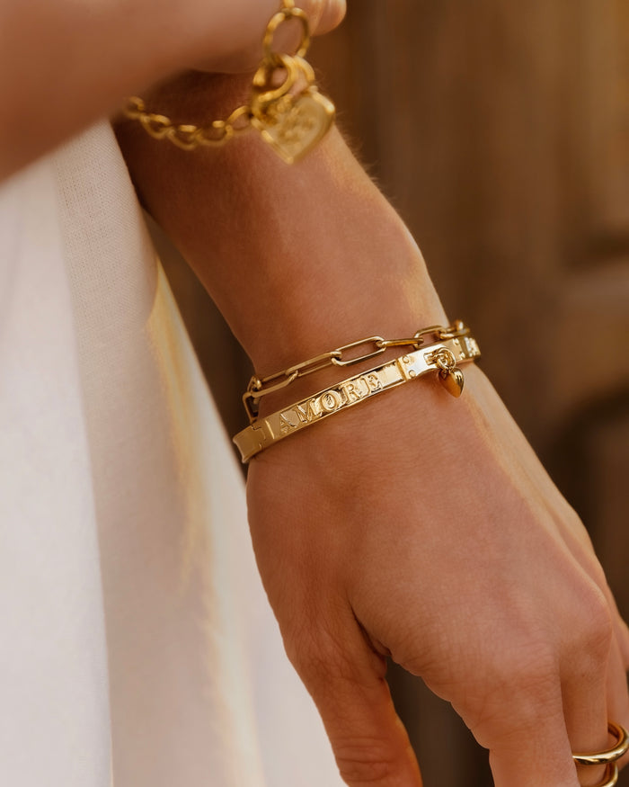 Hand wearing stacked gold bangle bracelets