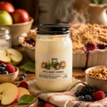 Jar of 'Apple Berry Crumble' candle with autumn-themed elements and food items in the background.