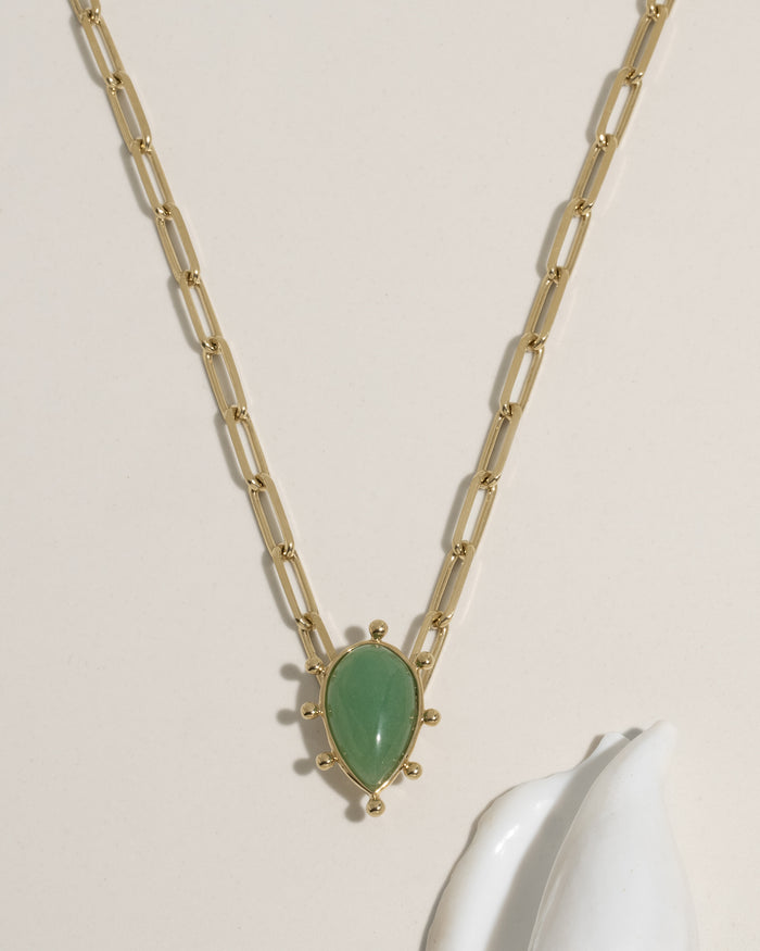 Gold paperclip chain necklace with teardrop green gemstone pendant and gold ball accents