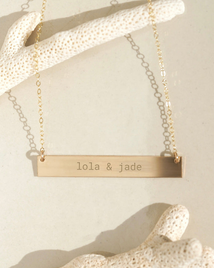 Gold horizontal bar necklace with custom engraved text
