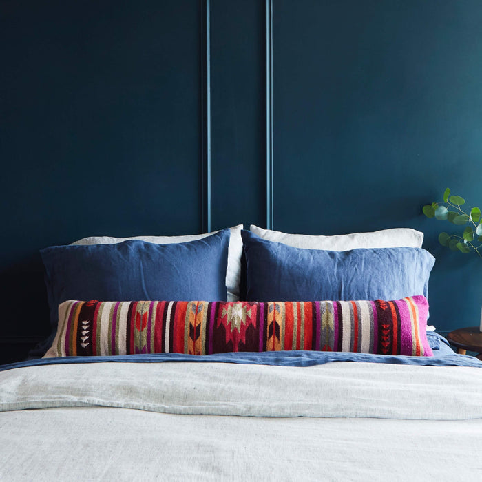 Geometric and striped oversized lumbar pillow styled on bed, multicolor