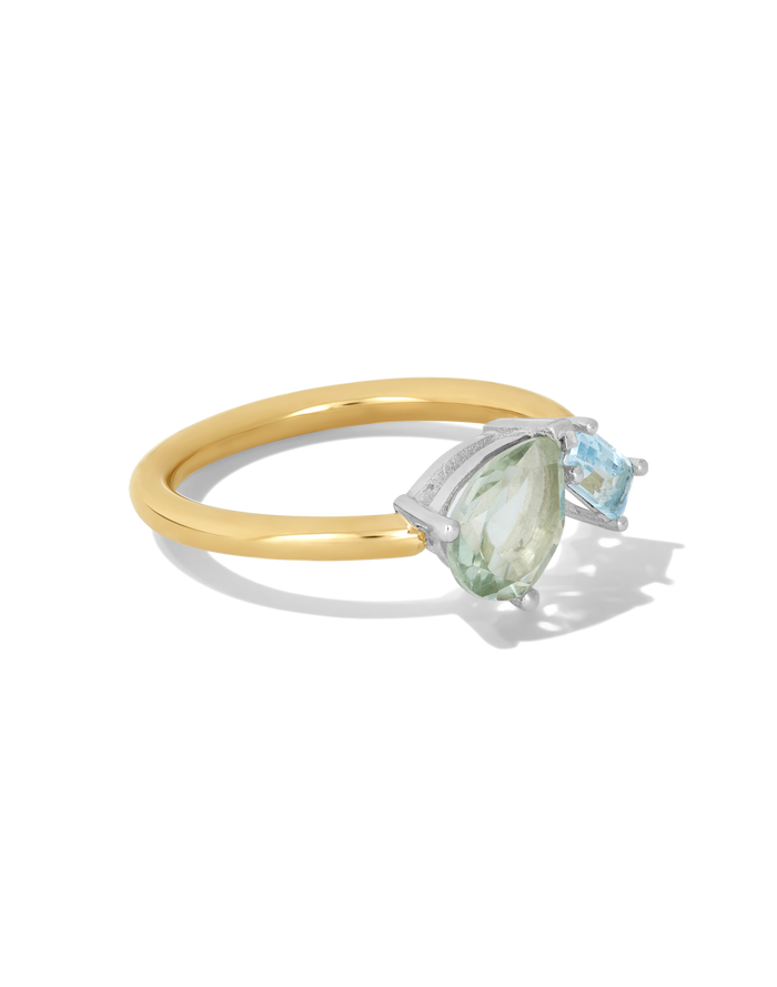 Gold band ring featuring a pear-shaped green stone and square blue topaz stone in silver prong settings