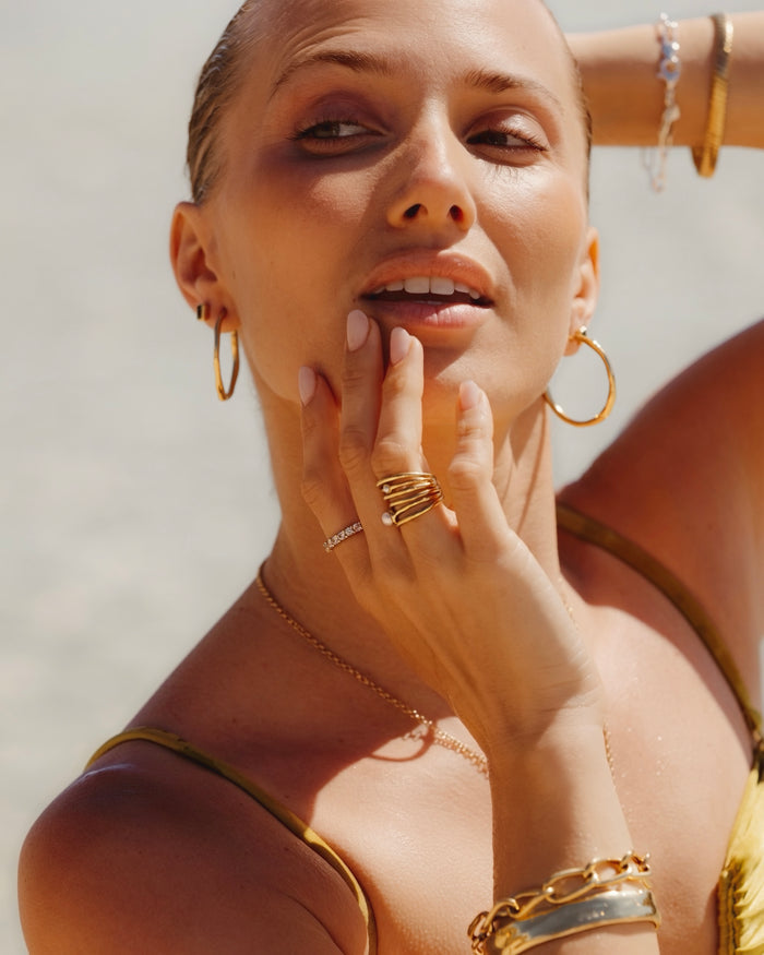 Gold ring with a pearl accent worn on a hand