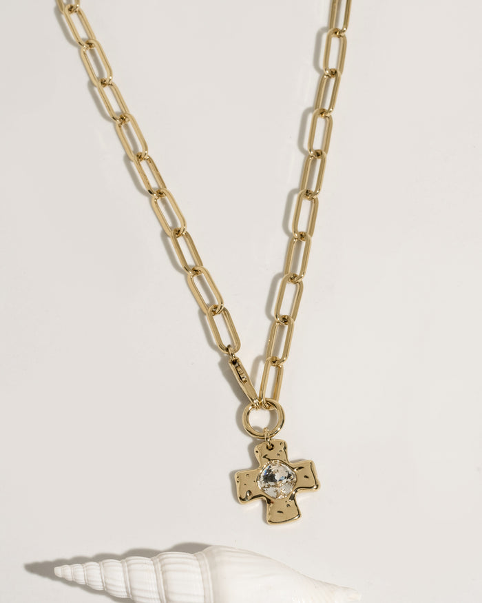 Gold necklace with pendant, flat lay