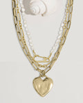 Gold chain necklace set with heart lock and pearl charms, flat lay