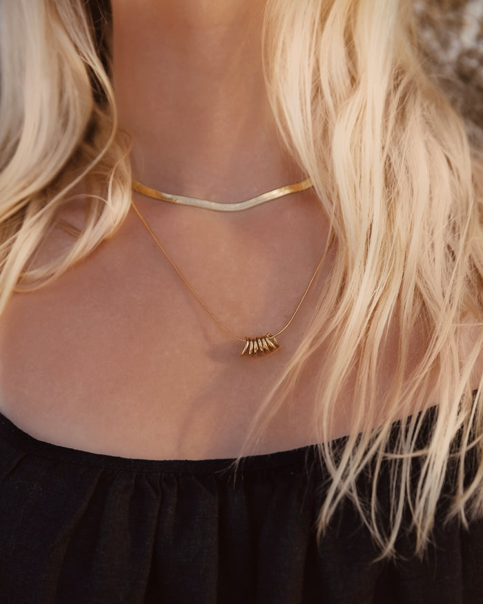 Close-up of a woman wearing a gold necklace