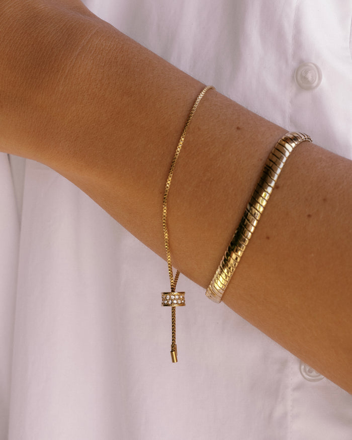 Gold adjustable bolo bracelet with crystal-encrusted sliding clasp on box chain, detail view