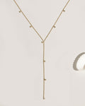 Gold lariat necklace with multiple bezel-set crystal charm drops on fine chain