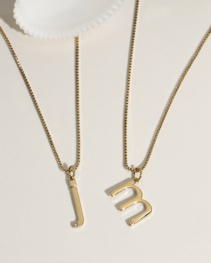 Layered gold necklaces with charms