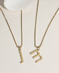 Layered gold necklaces with charms