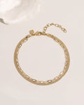 Two-layer gold anklet set combining flat herringbone chain and paperclip link chain, detail view