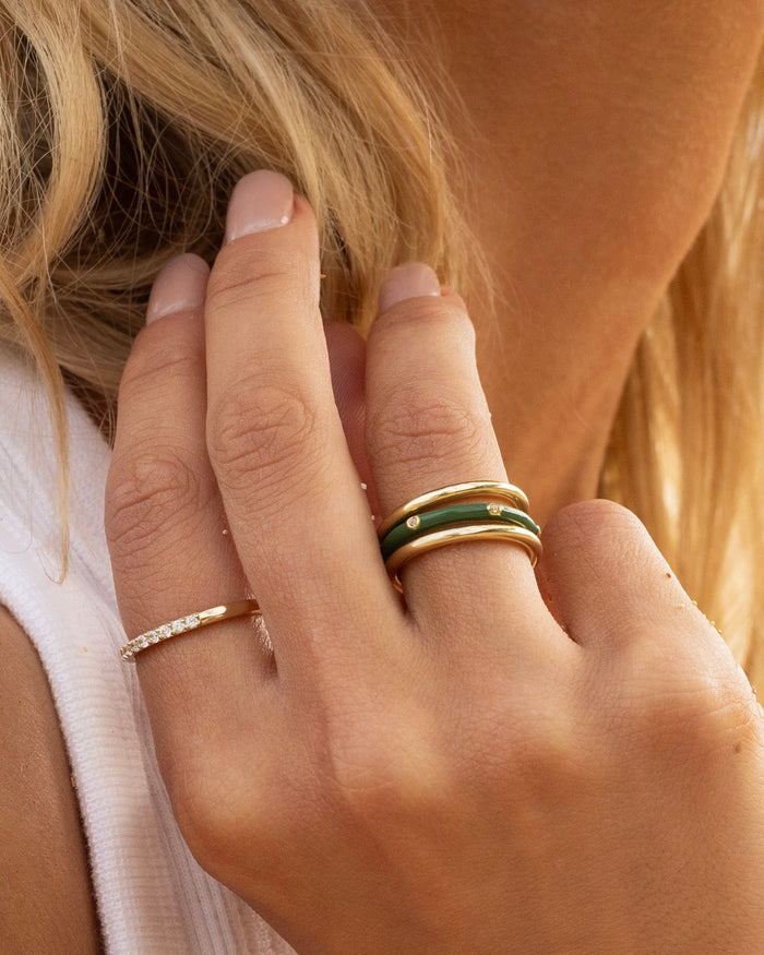 Set of gold stacking rings with colorful enamel accents, lifestyle shot worn by model