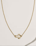 Delicate gold rolo chain necklace with tiny open cross pendant