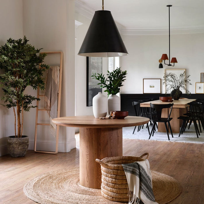 Neutral cream and black throw in basket in front of modern round table, cream