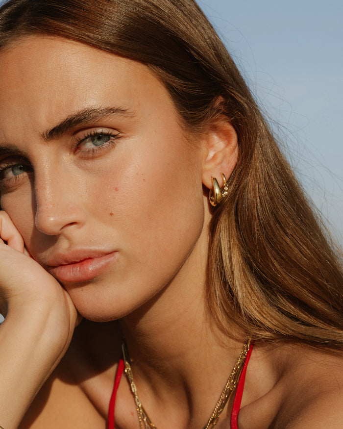 Woman wearing a gold necklace and earrings