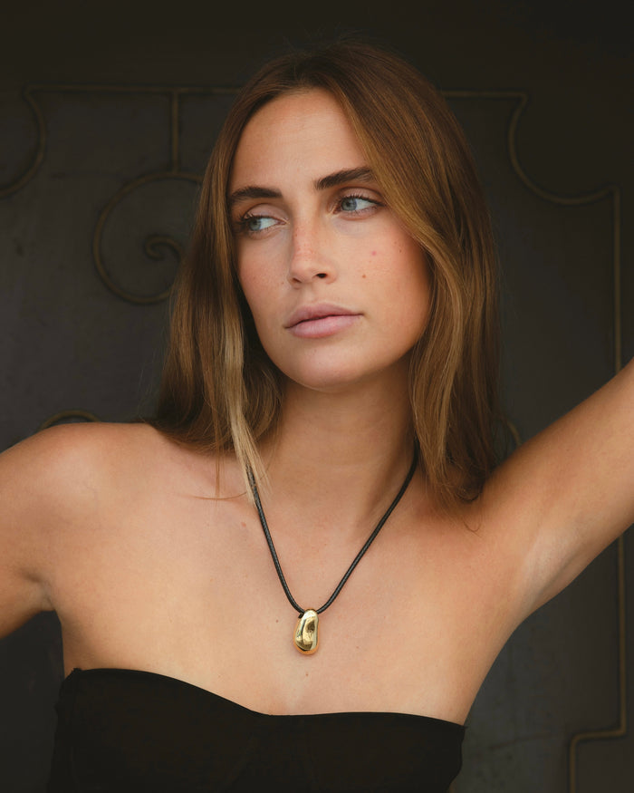 Woman with dark hair wearing a delicate layered necklace