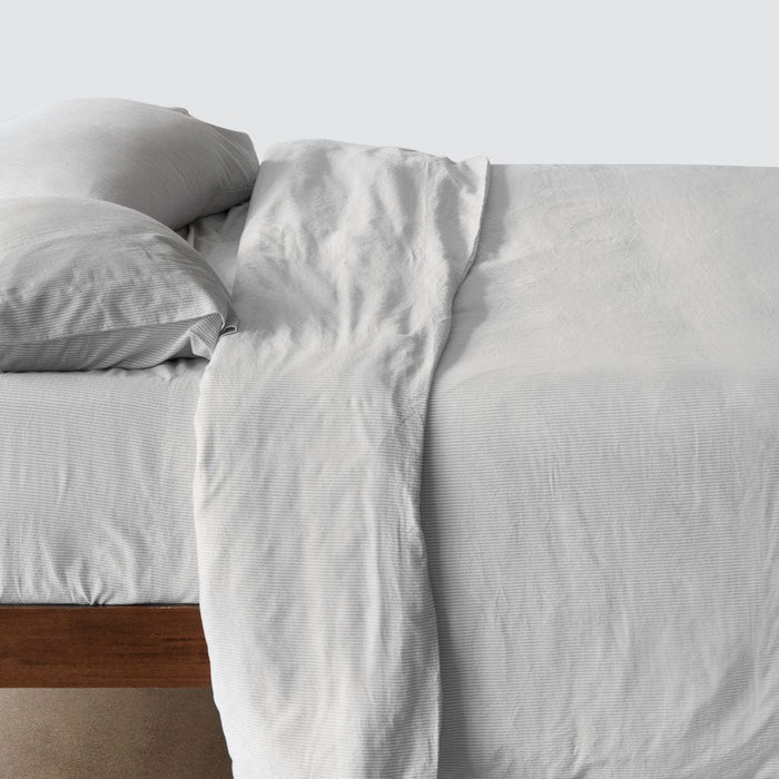 Side of bed with duvet and pillowcases, light-grey-stripe