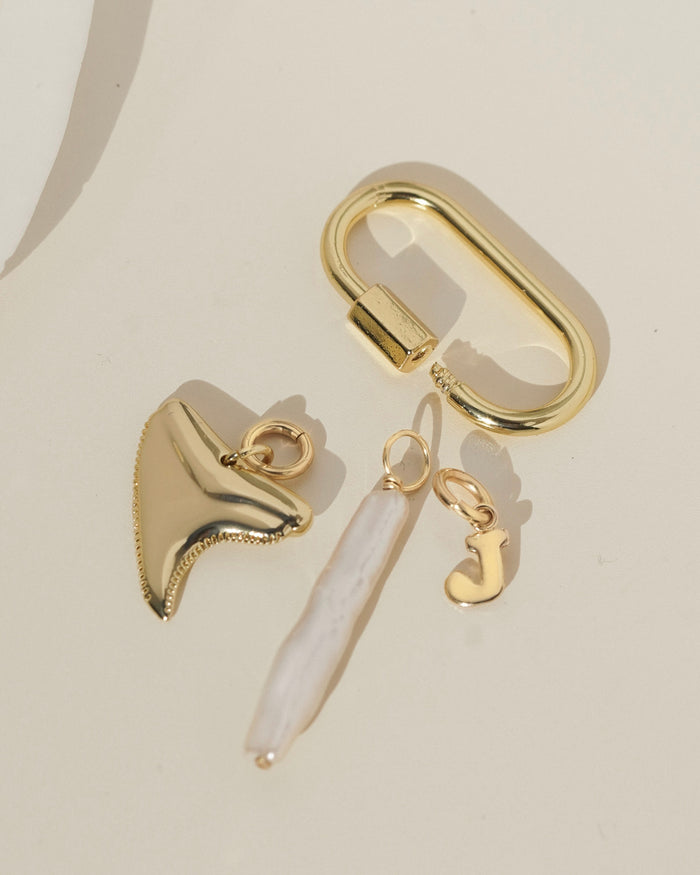 Gold earring with a dangling charm