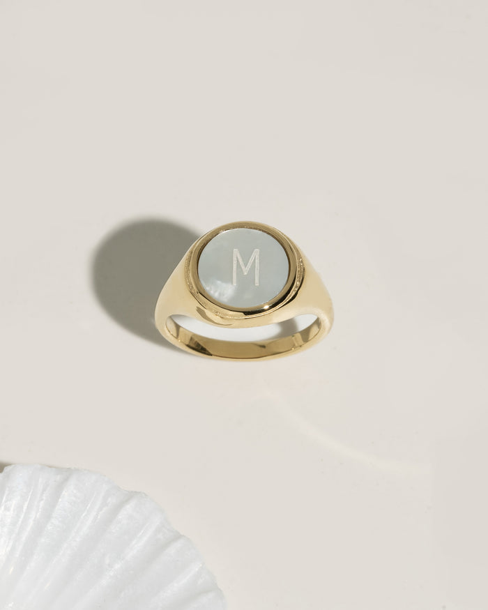 Gold signet ring with mother-of-pearl initial disc, product photo