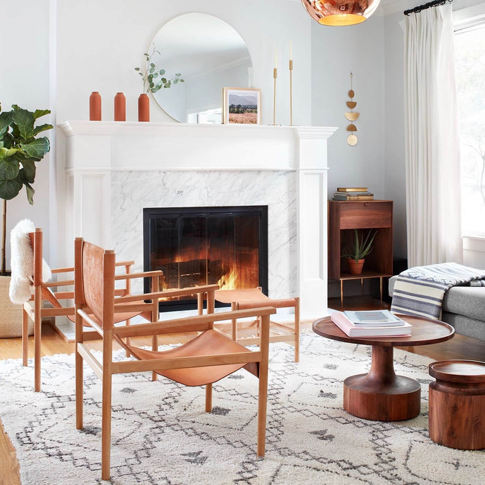 Brass wall hanging in alcove next to white marble fireplace, brass