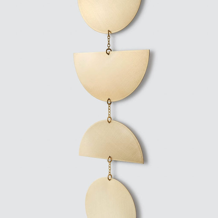 Detailed view of chain links between each brass piece of metal wall hanging, brass