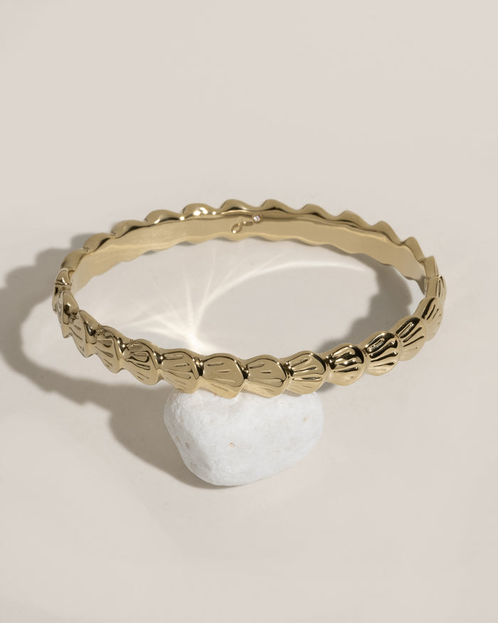 Gold beaded bracelet with tiny white shell charm pendant
