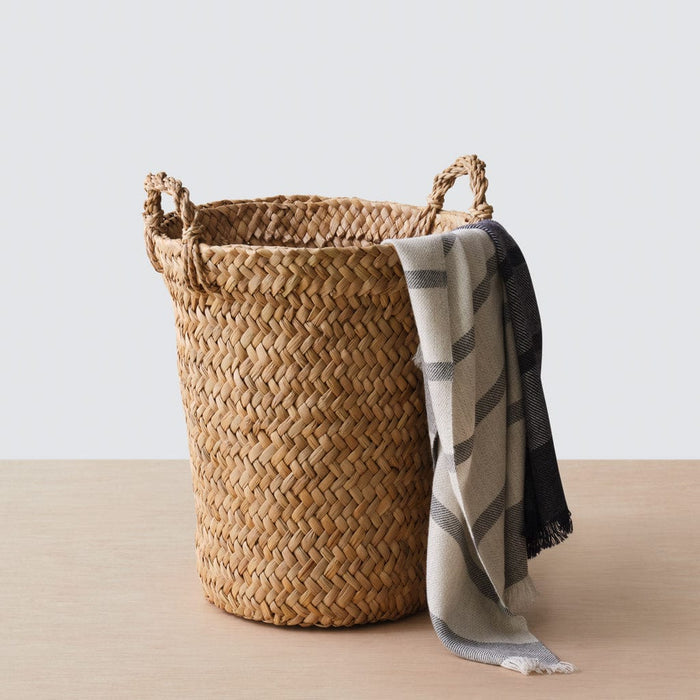 Woven throw laying over edge of basket