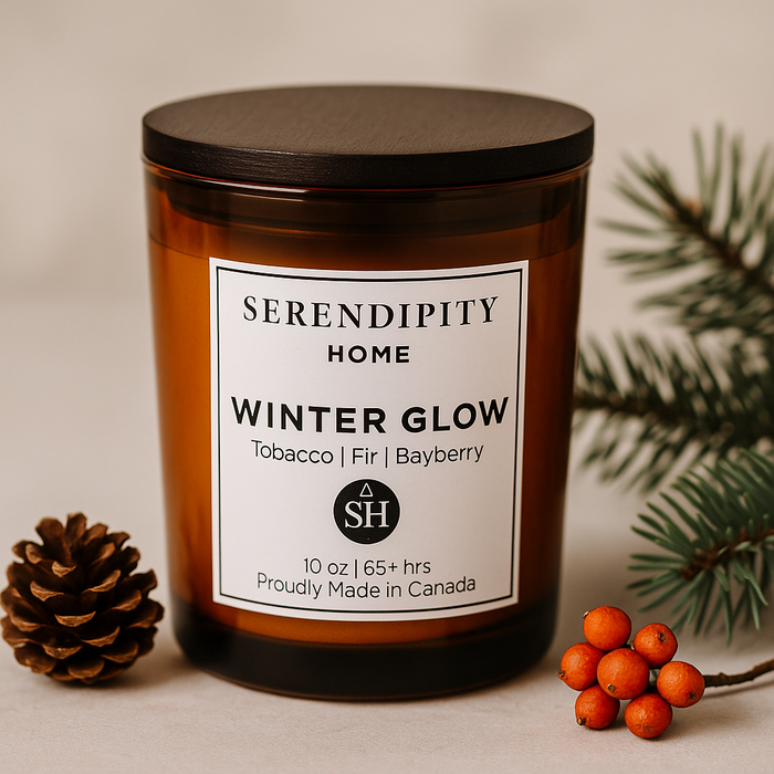 Scented candle labeled 'Winter Glow' by Serendipity Home with decorative elements on a neutral background.
