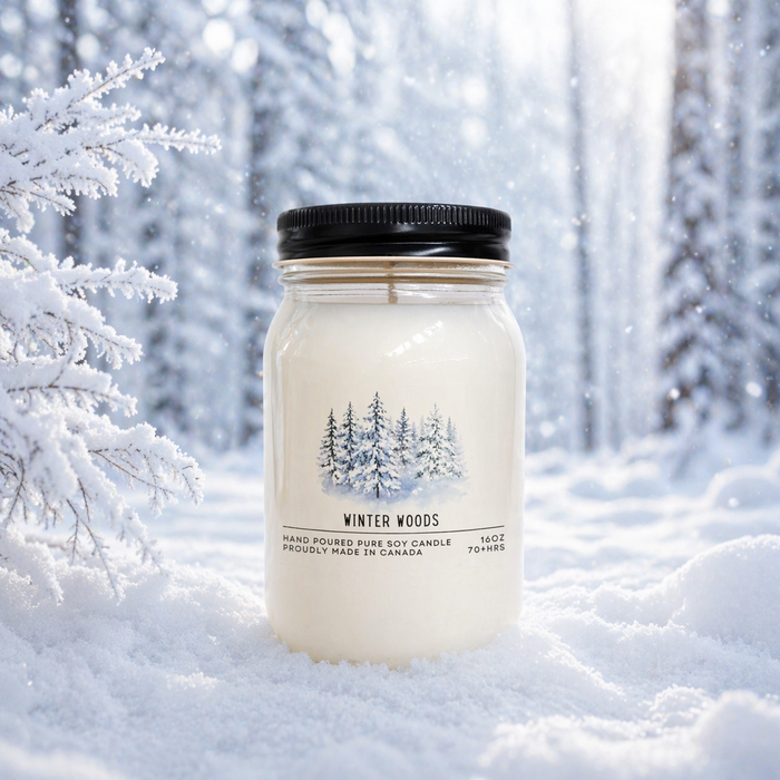 Candle jar labeled 'Winter Woods' in a snowy forest setting